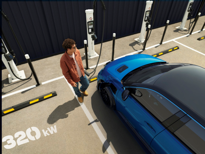Man in rust coloured shirt and jeans at Mobilize charging station charging an Alpine A290